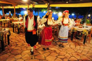 un grupo de personas bailando frente a un restaurante en Hotel Penelope, en Boukari