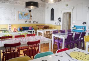 a dining room with tables and colorful chairs at Lisb'on Hostel in Lisbon