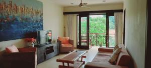 Una sala de estar con un sofá y un televisor. en Bali Paradise Apartments, en Sanur