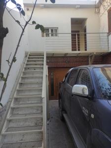 samochód zaparkowany przed domem ze schodami w obiekcie Belgrano 658 Nqn - Piso 1 Dto 2 w mieście Neuquén