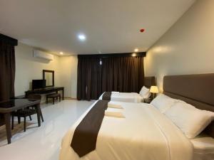 una camera d'albergo con un grande letto e una scrivania di Eight Breeze a Baclayon