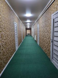 Кольсайские озера, гостиница Айару في Kurmenty: ممر طويل مع الأرضيات والأبواب الخضراء