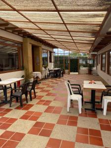 un patio con mesas, sillas, mesas y ventanas en Hostal Villa Anita, en Villa de Leyva