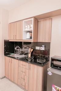 a kitchen with wooden cabinets and a stove top oven at StayEasy Tsavo in Nairobi