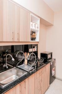 a kitchen with a sink and a dish drying rack at StayEasy Tsavo in Nairobi