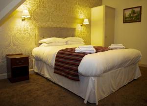 a hotel room with a large bed with towels on it at Strawberry Bank Hotel, NEC in Meriden +49 photos