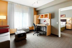 a hotel room with a desk and a bed and a bedroom at TownePlace Suites by Marriott Harrisburg Hershey in Harrisburg