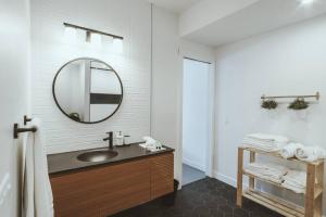a bathroom with a sink and a mirror at NYC Loft Inspired •12 mins to WEM •Vintage arcade in Edmonton +37 photos