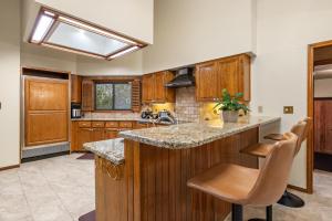 una cocina con armarios de madera y una isla con taburetes en Villa Española en San Antonio