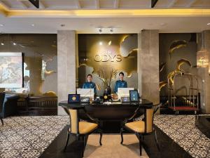 two men standing at a desk in a hotel lobby at The Odys Boutique Hotel in Ho Chi Minh City