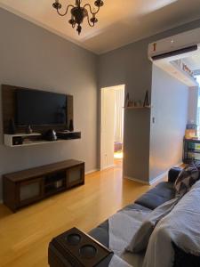 uma sala de estar com um sofá e uma televisão de ecrã plano em Catete 247 no Rio de Janeiro