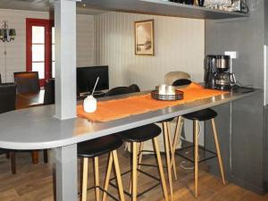 uma cozinha com um bar com bancos à volta em Holiday home Selje III em Selje