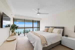 a bedroom with a bed and a large window at Gemini Court Holiday Apartments in Gold Coast