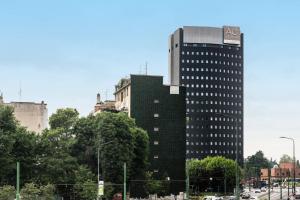 Un alto edificio nero nel bel mezzo di una città di AC Hotel Milano by Marriott a Milano