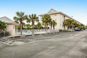 un parking vide en face d'un immeuble planté de palmiers dans l'établissement Gulf Island 223, à Navarre