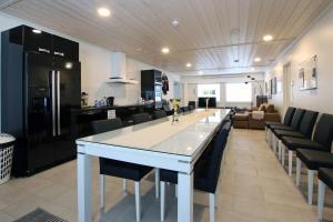 a kitchen and living room with a long table and chairs at JM Rally Parc Ferme Rallimuseo in Tuuri