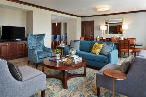 sala de estar con sofá azul y sillas en Renaissance Montgomery Hotel & Spa at the Convention Center, en Montgomery