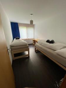 a bedroom with two beds and a table in it at Ferienwohnung "Spel Rein" Cumpadials inmitten der Surselva in Compadials