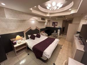 a hotel room with a bed and a table at hotel purpleeye in Osaka