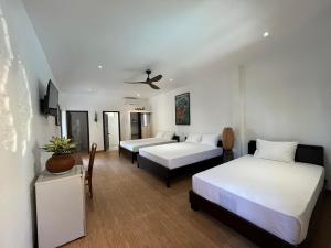 um quarto de hotel com duas camas e uma televisão em Mi Nhon Em Hotel Muine em Mui Ne