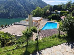 una casa con piscina junto a un lago en Exklusive Zweizimmerwohnung mit Pool und Seesicht, en Rovio