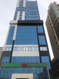 un edificio alto con un cartel de hotel canadiense en Garden Hotel en Kuwait