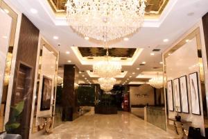 un vestíbulo con una gran lámpara de araña y espejos en Garden Hotel en Kuwait