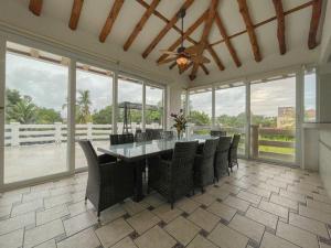 uma sala de jantar com mesa, cadeiras e janelas em Casa Villa Serena Coronado em Chame