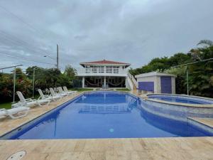 uma grande piscina com cadeiras e um edifício em Casa Villa Serena Coronado em Chame