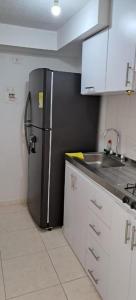 a kitchen with a black refrigerator and a sink at Apartamento en Cúcuta completó en condominio 17 in Cúcuta