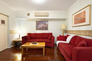 a living room with two red couches and a table at Northbridge Pearl in Perth