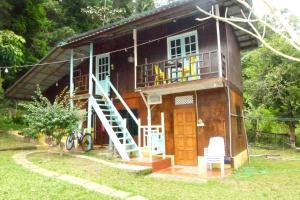 Cheers Garden Chalet في Kampung Tekek: منزل صغير به درج وشرفة