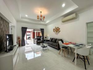 a living room with a couch and a table at VIEW TALAY VILLAs POOL 119, JOMTIEN BEACH, PATTAYA in Jomtien Beach