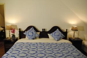 a bedroom with a bed with blue and white pillows at Quinta Mar & Sol in Funchal