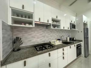 a kitchen with white cabinets and granite counter tops at VIEW TALAY VILLAs POOL 119, JOMTIEN BEACH, PATTAYA in Jomtien Beach +12 photos