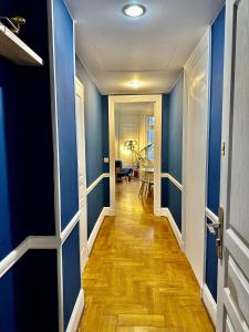 a hallway with blue walls and a wooden floor at Luxurious Apartment with AC Promenade des Anglais up to 4 people B in Nice