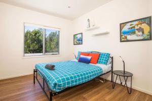 - une chambre avec un lit doté d'oreillers bleus et oranges dans l'établissement Thalassa I Pet Friendly I 2 Mins Walk to Beach, à Culburra Beach
