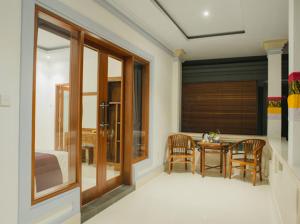 una camera con una camera da letto con un tavolo e un letto di Pandu guest house ad Ubud