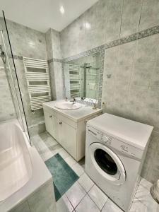 a bathroom with a washing machine and a sink at Luxurious Apartment with AC Promenade des Anglais up to 4 people B in Nice