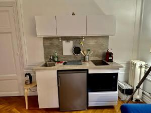 a kitchen with white cabinets and a black dishwasher at Luxurious Apartment with AC Promenade des Anglais up to 4 people B in Nice