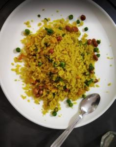 a white plate with rice and beans and a spoon at Budget Hotel in Patna