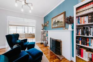 a living room with blue walls and a fireplace at Mortimer Cottage - A Pool Oasis in Heart of Mudgee in Mudgee