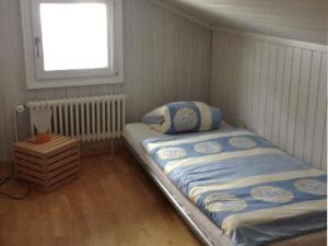 ein kleines Schlafzimmer mit einem Bett und einem Fenster in der Unterkunft Helvetia Heinemann 4 Bett Wohnung in Mürren