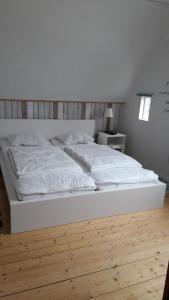 a white bed in a bedroom with a wooden floor at Ferienhaus in Storfors mit Großem Garten in Storfors
