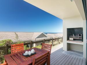 クニスナにあるBrenton Haven Beachfront Resortの木製デッキ(テーブル、椅子付)