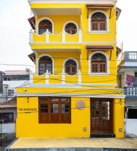 a yellow building with a sign on it at The Barracks Cochin in Cochin