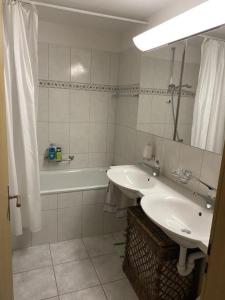 a bathroom with a sink and a tub and a mirror at Ferienwohnung mit Aussicht bei Golfplatz Buna Vista in Schleuis