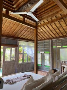 Sarini Villas في بلاهباتو: غرفة نوم بسرير ومروحة سقف