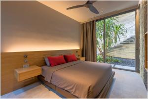 a bedroom with a bed with red pillows and a window at The Cube Ocean View Pool Villa Kalim in Patong Beach