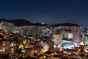 una ciudad iluminada por la noche con edificios en Stay Ami #GamcheonCultureVillage#Nampodong#Family, en Busan